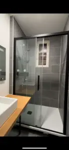 La salle de douche a tout l'équipement de qualité pour un confort d'utilisation : cabine avec porte coulissante, miroir avec dégivrage et lampe intégrée, évier large et design, radiateur porte essuie